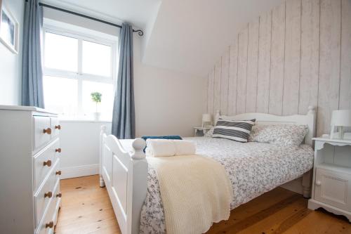 a bedroom with a white bed and a window at Beautiful coastal house at the Drowes Rivermouth in Bundoran