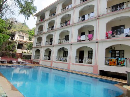 un hotel con piscina di fronte a un edificio di Riverside Regency Resort a Baga