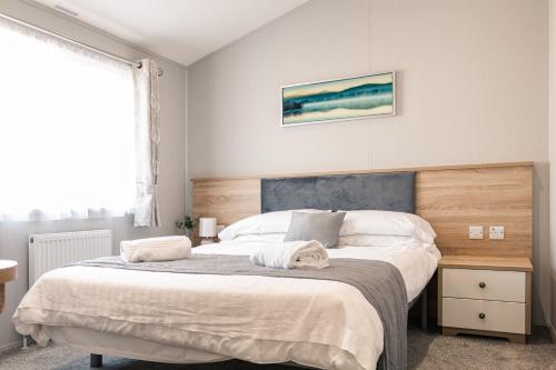 um quarto com uma cama grande e uma cabeceira em madeira em Lilac Lodge with Hot Tub em York
