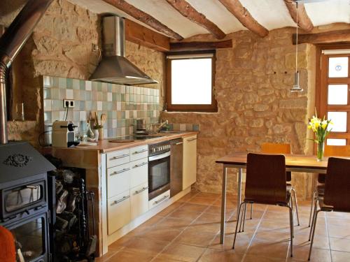 eine Küche mit einem Tisch und einem Herd in der Unterkunft Alojamiento La Fresneda in La Fresneda