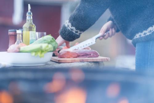 a person cutting up vegetables on a cutting board at Lilla Trulsabo in Skillingaryd