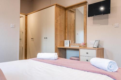 a bedroom with two beds with a mirror and a desk at Lavender Lodge with Hot Tub in York