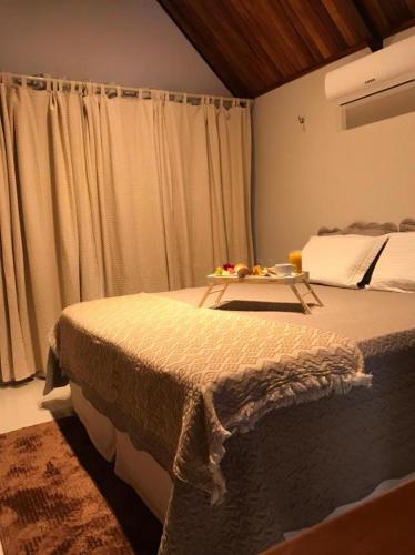 a bedroom with a bed with a tray of fruit on it at Hotel Chale Lagoa Dos Ingas in Martins