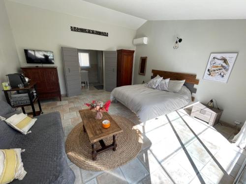 奧賴松的住宿－Gîte La maison dans l'Olivette，客厅配有床和桌子