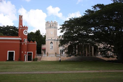 a building with a tower with a clock on it at Hacienda San Antonio Millet in Tixkokob