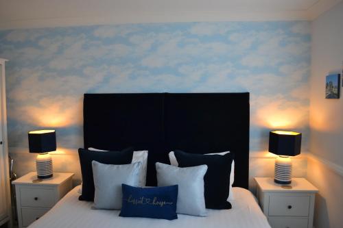 a bedroom with a large bed with two lamps on tables at Harriet House B&B in Canterbury