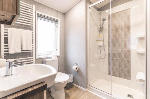 a bathroom with a sink and a toilet and a shower at Lakeside View Lodge with Hot Tub in York