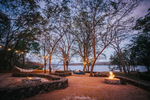 a hammock and fires in a park at night at Papagayo Golden Palms Beachfront Hotel in Papagayo, Guanacaste