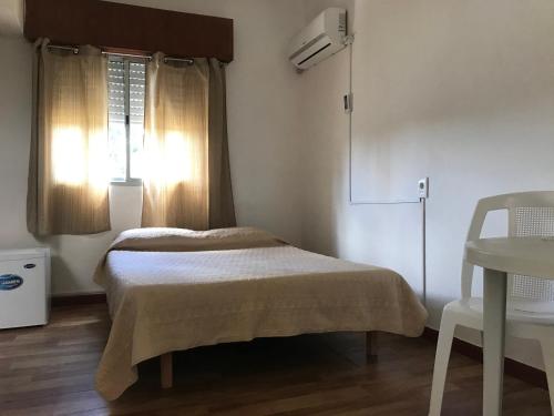 a bedroom with a bed and a table and a window at Departamentos LT3 in Las Toscas