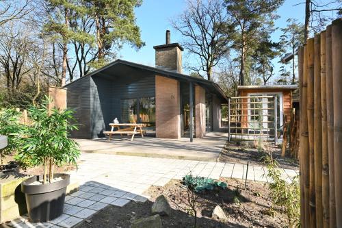 a small house with a glass extension in a garden at ZEN-bungalow NO 1 met sauna en hottub in Rheezerveen