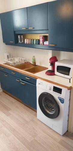 uma cozinha com uma máquina de lavar roupa e um micro-ondas em Aux Alyscamps em Arles