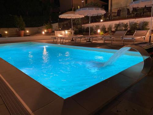 a swimming pool at night with a water fountain at Villa Margherita in Cefalù