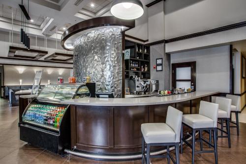 un bar dans un restaurant avec un comptoir et des tabourets dans l'établissement Hyatt Place Fort Worth / Cityview, à Fort Worth