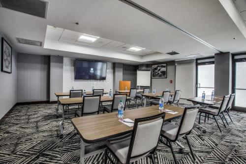 a conference room with tables and chairs and a screen at Hyatt Place Fort Worth / Cityview in Fort Worth