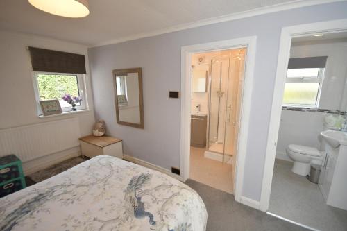 a bedroom with a bed and a sink and a toilet at Hare Lodge in Woodhall Spa