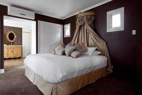 a bedroom with a large bed with a canopy at The Castle on Tamborine in Mount Tamborine