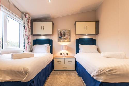two beds sitting next to each other in a room at The Crucible lodge with Hot Tub in York
