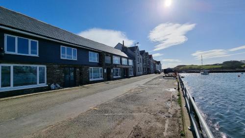 a street with buildings next to a body of water at The Steam Packet Inn in Isle of Whithorn