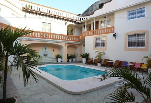 a house with a swimming pool in a courtyard at Hotel OM Tangolunda in Tangolunda