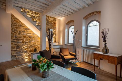 a living room with a table and chairs and a brick wall at old medieval apartment in San Donato in Poggio