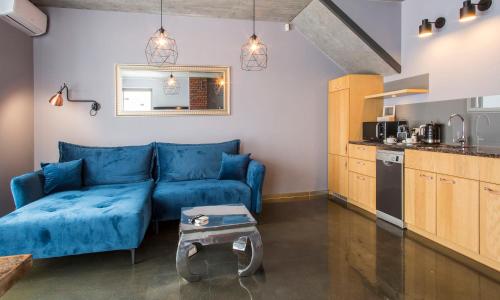 a living room with a blue couch and a table at Słoneczny Chełm - Apartamenty w górach, Prywatna sauna jacuzzi balia w cenie, Spa, Grill, Stok narciarski Myślenice, Ścieżki rowerowe, Rzeka Raba, Widok na Tatry in Myślenice