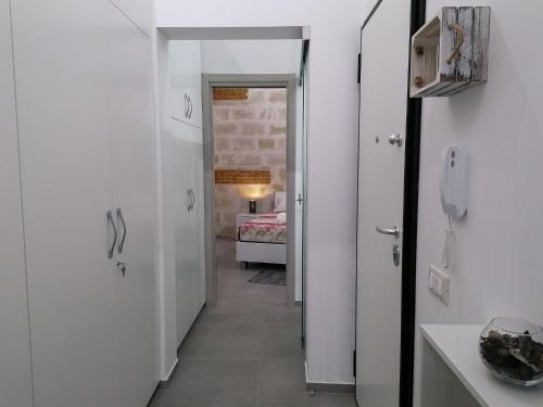 a hallway with white walls and a room with a bed at Suite Torre Pali in Trapani