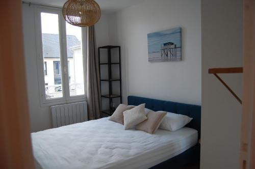 una camera da letto con un letto con lenzuola bianche e una finestra di POISSY Appartements COSY a Poissy