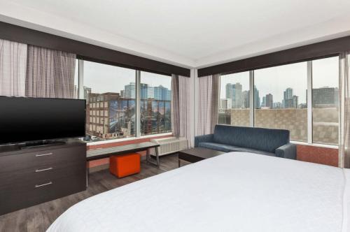 a hotel room with a bed and a large window at Holiday Inn Express & Suites Jersey City - Holland Tunnel, an IHG Hotel in Jersey City