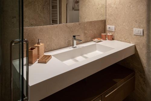 a bathroom with a white sink and a mirror at old medieval apartment in San Donato in Poggio