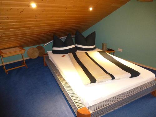 a bed with black pillows on it in a room at Eifel Panoramablick in Kelberg