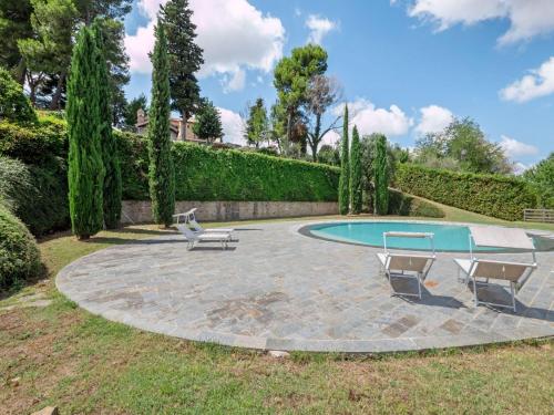 a patio with two chairs and a pool at Apartment in Villagrande with Pool & Garden in Mombaroccio