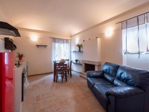 a living room with a leather couch and a table at Apartment in Villagrande with Pool & Garden in Mombaroccio