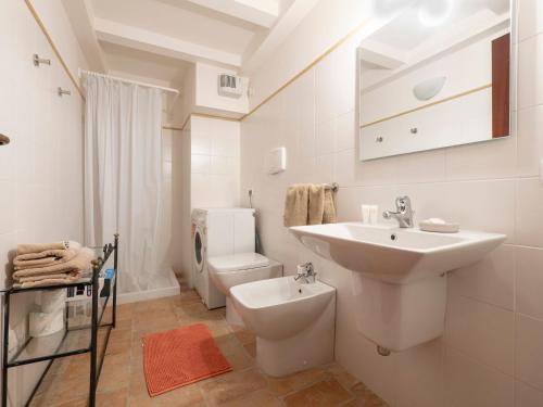 a white bathroom with a sink and a toilet at Apartment in Villagrande with Pool & Garden in Mombaroccio