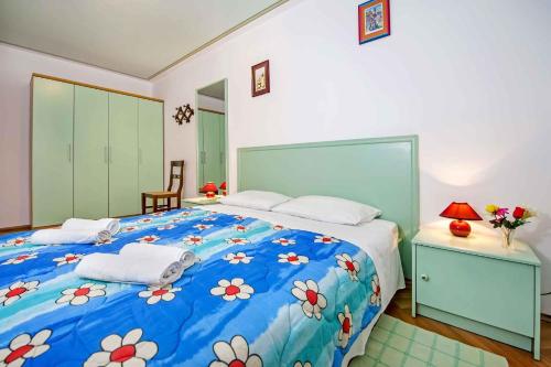 a bedroom with a blue bed with flowers on it at Apartment in Rovinj with Two-Bedrooms 5 in Štanga