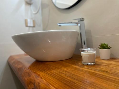 a bowl sink on a wooden counter with a glass of milk at Relais Petruzzelli in Bari