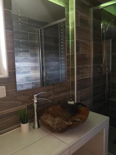 a bathroom with a sink with a mirror and a shower at L'Imprévu Saint Lary Soulan in Saint-Lary-Soulan