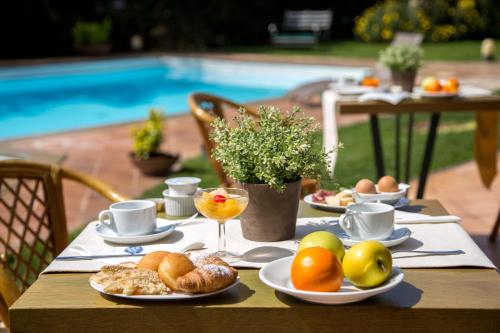 a table with plates of food on a table near a pool at Best Western Park Hotel Roma Nord in Fiano Romano