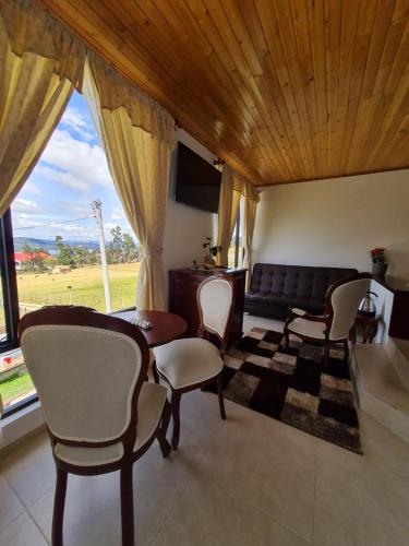 a living room with a couch and a table and chairs at ReLuna Guatavita Glamping & Suites in Guatavita