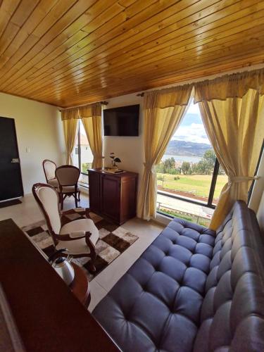 a living room with a couch and a large window at ReLuna Guatavita Glamping & Suites in Guatavita