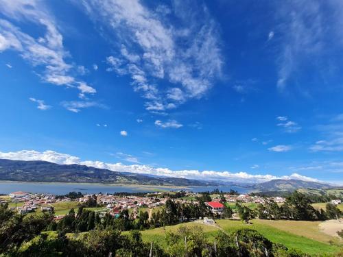 a town on a hill next to a body of water at ReLuna Guatavita Glamping & Suites in Guatavita