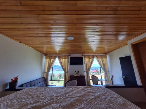 a bedroom with a bed with a wooden ceiling at ReLuna Guatavita Glamping & Suites in Guatavita