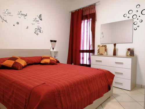 - une chambre avec un lit doté d'une couverture rouge et d'une commode dans l'établissement LUX IUN Q2026, à Lanusei