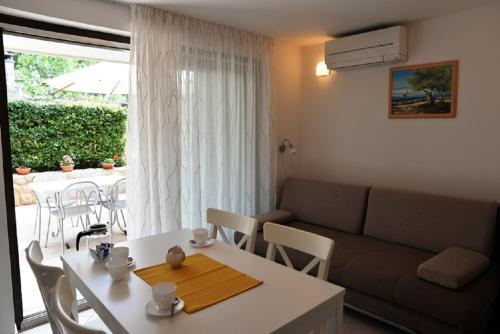 uma sala de estar com uma mesa branca e um sofá em Apartments Forna - free parking em Cres