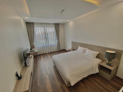 a hotel room with a bed and a television at Mansion Park Hotel & Apartment in Bien Hoa