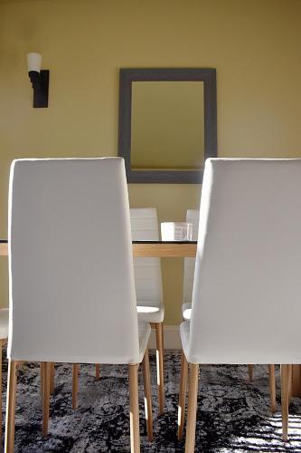 two white chairs sitting next to a table with a mirror at Villa Luna in Gig Harbor