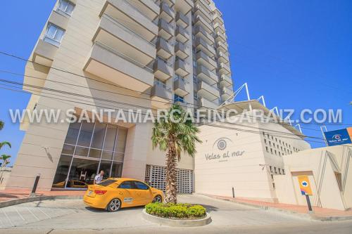 a yellow car parked in front of a building at Velas Al Mar - Apartamento Rodadero Gaira in Gaira