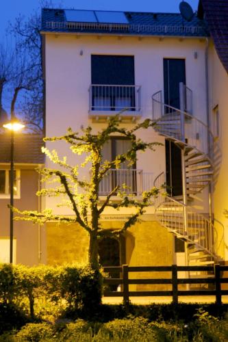 a white building with a tree in front of it at Alte Stadtmauer - Apartment in Sinsheim