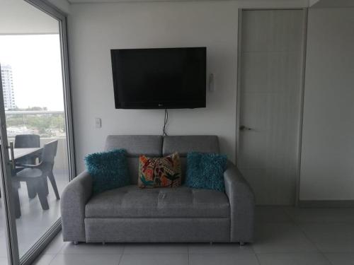 a living room with a couch and a flat screen tv at Velas Al Mar - Apartamento Rodadero Gaira in Gaira