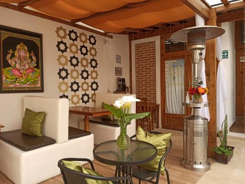 a living room with a table and chairs at Ganesha Hotel in San Cristóbal de Las Casas