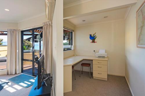 a home office with a desk and a television at On The Rocks in Nelson